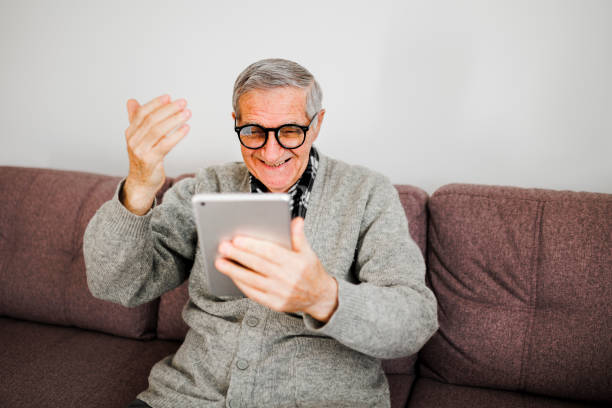 istock Senior man making video call on digital tablet at home 1365914728