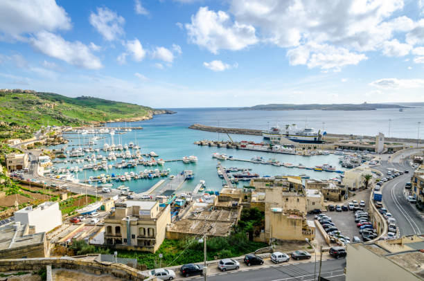 Panoramic view of Mgarr Harbour in Gozo, Malta stock photo Panoramic view of Mgarr Harbour in Gozo, Malta. Several boats are moored and the car ferry is docked mgarr malta island gozo cityscape with harbor stock pictures, royalty-free photos & images
