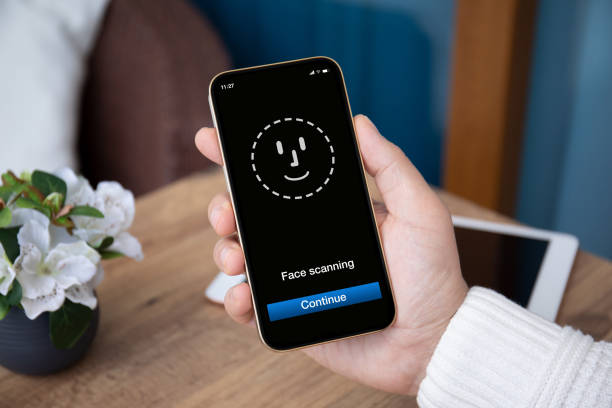 istock male hand holding phone with face ID scanning on screen 1365917664