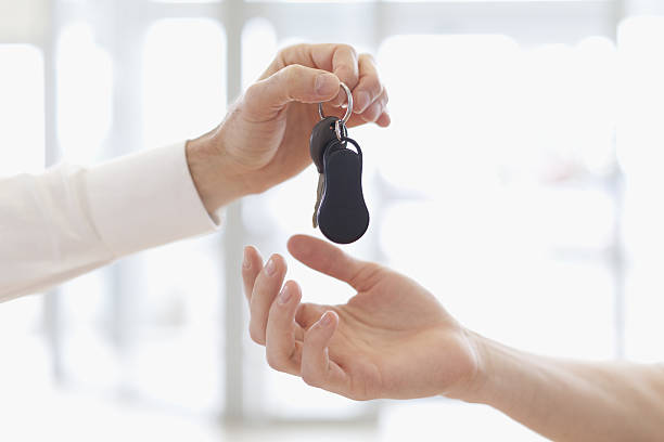 Car salesman handing keys to customer  car ownership photos stock pictures, royalty-free photos & images