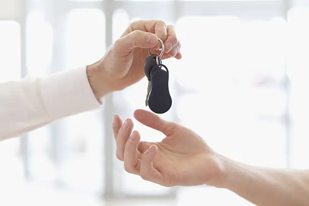 Photo of Car salesman handing keys to customer