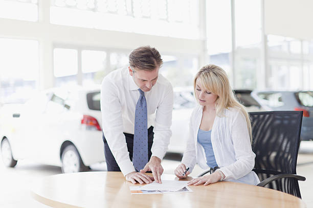 cliente firma in concessionaria automobilistica - focus on foreground selective focus focus household equipment foto e immagini stock