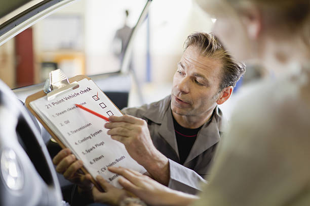 mecánico muestra una lista de control para el cliente - customer auto repair shop car mechanic fotografías e imágenes de stock