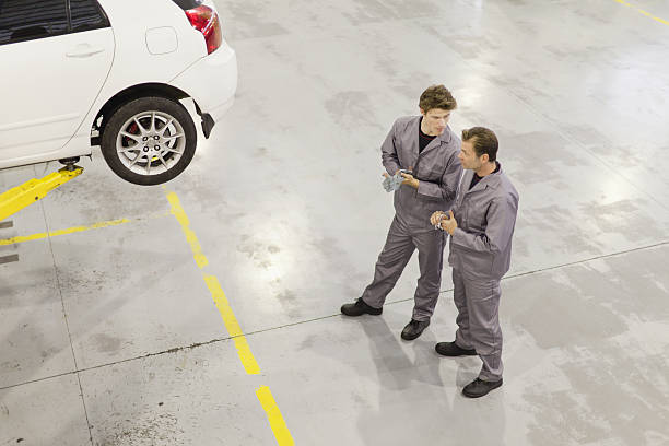 Mechanics talking in garage car mechanic top view stock pictures, royalty-free photos & images