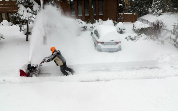 Man using snowblower in deep snow stock photo