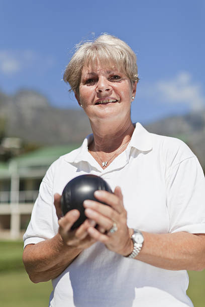 femme jouant d'un bowling sur gazon - anticipation smiling touching image technique photos et images de collection