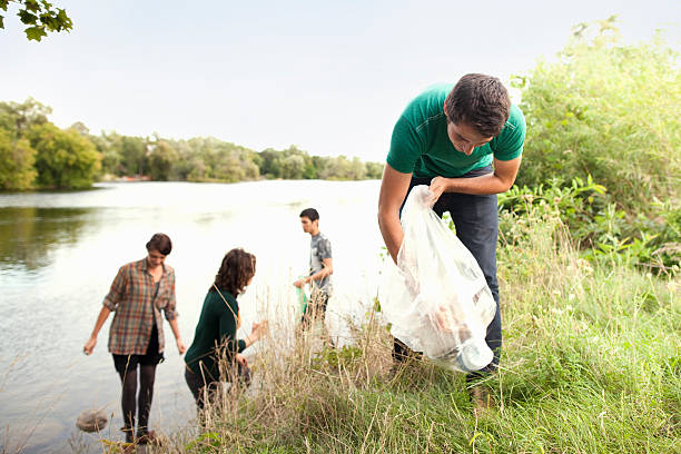 gente recolección de basura en el parque - conservacionista fotografías e imágenes de stock
