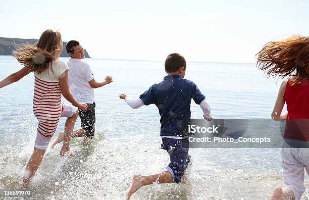 Photo libre de droit de Enfants Courir Dans Les Vagues Sur La Plage banque d'images et plus d'images libres de droit de Cornouailles - Cornouailles, Personne humaine, 10-11 ans