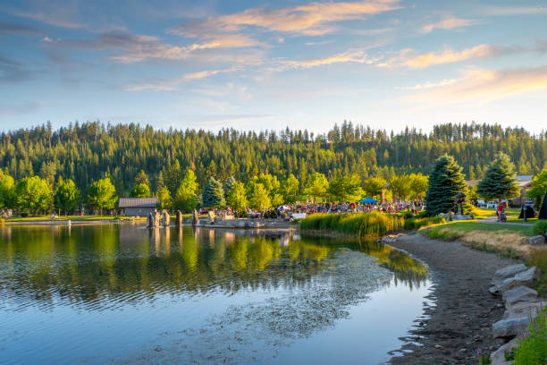 un concerto gratuito all'aperto sul piccolo lago nel riverstone park pubblico al tramonto a coeur d'alene, idaho, usa - idaho foto e immagini stock