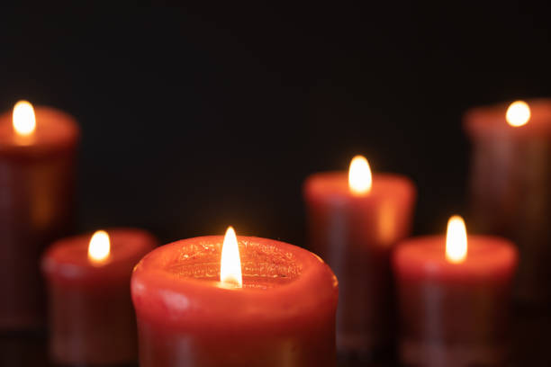 istock Red candles burning in a dark room 1365923339