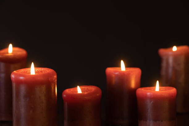 Red candles burning in a dark room with copy space in black background