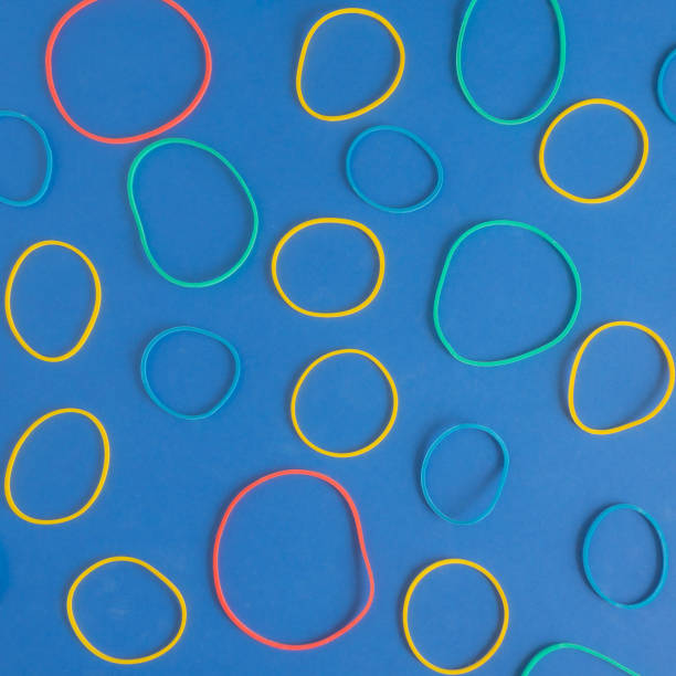 istock Creative pattern of hair ties rubber bands on a vibrant blue background. Square frame. Yellow, red, blue, green color. Flat lay arrangement. 1365926015