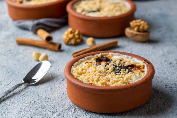 budino di riso al forno sutlac turco al latte in casseruola di terracotta con nocciole - rice pudding foto e immagini stock