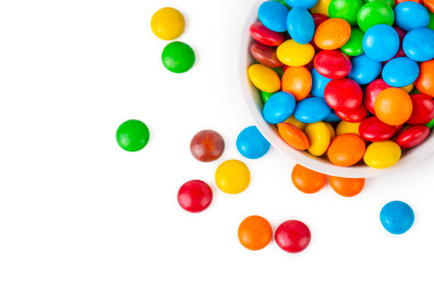 colorful chocolate buttons on a white background - candy coated imagens e fotografias de stock