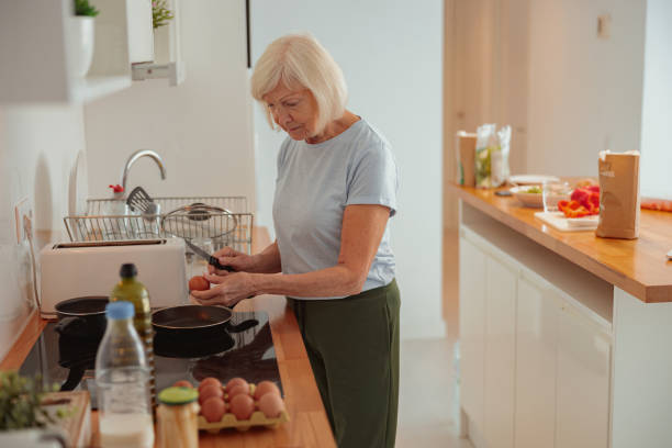 istock Elderly woman cooking in kitchen at home 1365933235