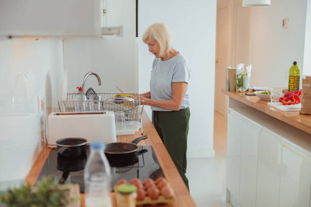 istock Pension age lady cleaning kitchen at home 1365933237