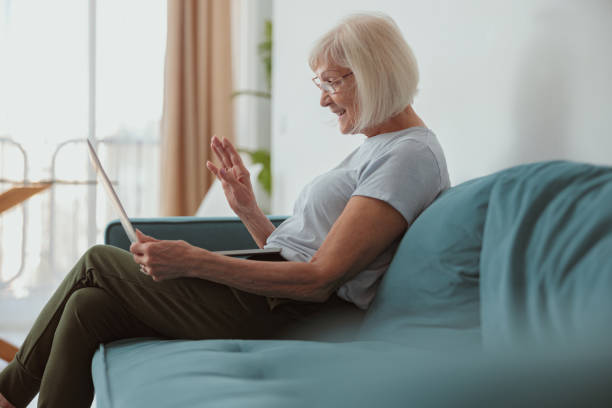 istock Concentrated elderly woman working at laptop indoors 1365933255