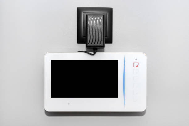 istock Videophone mounted on the wall with the black screen turned off, visible power supply with a cable. 1365933489