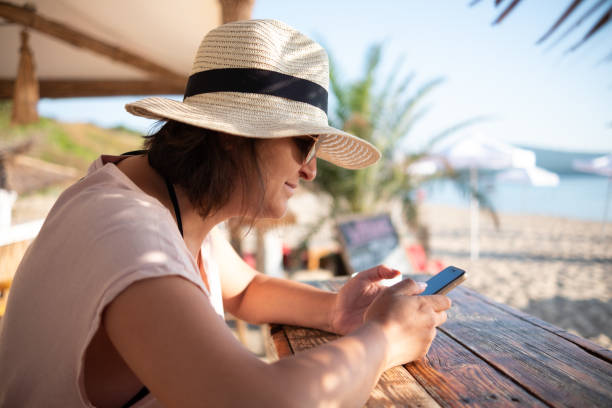 istock Girl with Phone on Beach Bar 1365933769