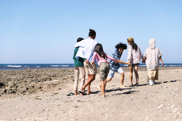 istock A asian family taking a walk on the beach. 1365934283
