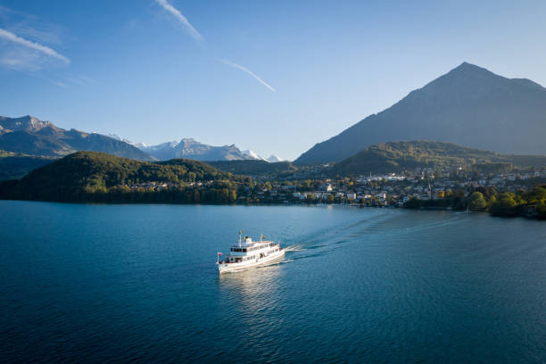 vista drone de barco cruzando o lago com montanhas acima - thun aerial view switzerland tree - fotografias e filmes do acervo