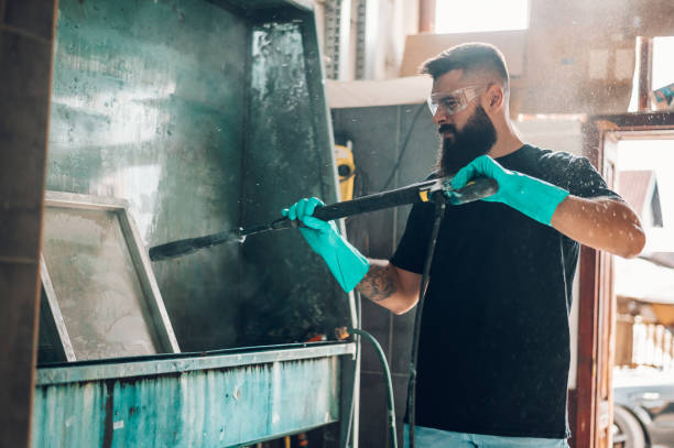 istock Male worker cleaning screen frame with water in a printing workshop 1365940941