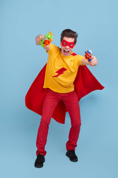 istock Funny superhero man with water guns in studio 1365941096