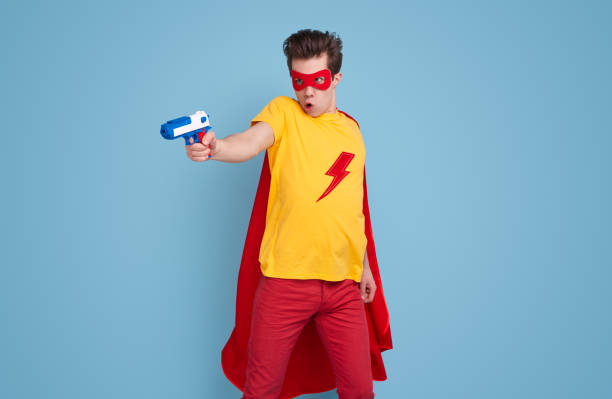 istock Funny superhero with water gun in studio 1365941098