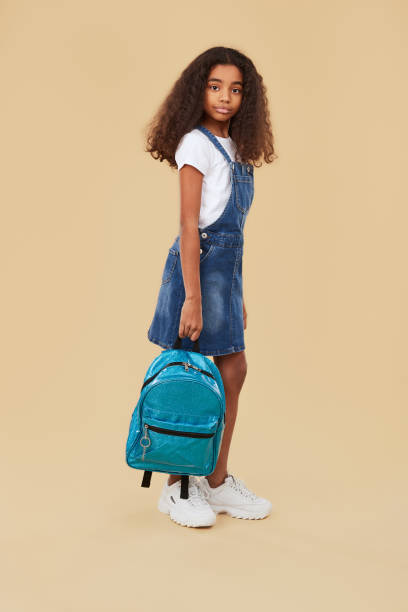 istock Ethnic schoolgirl in denim outfit with backpack 1365941166