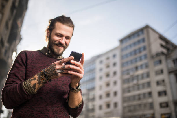 istock Young man using phone in the city. 1365949707