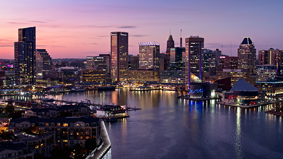 Drone shot of Baltimore, Maryland, flying over the water of the Inner Harbor and looking over the waterfront towards the downtown towers. \n\nAuthorization was obtained from the FAA for this operation in restricted airspace.