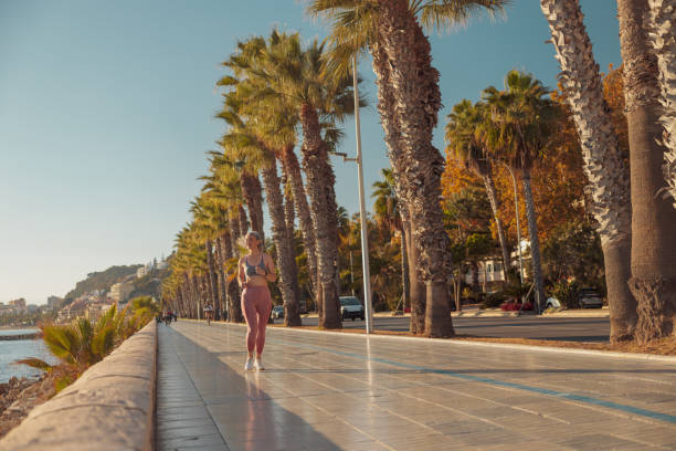 istock Sporty happy female actively running by the waterfront 1365955766