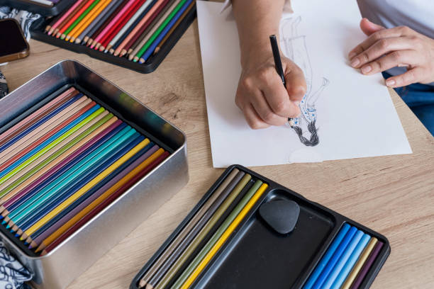 istock Designer makes new designs while painting them on paper with her colors 1365957876