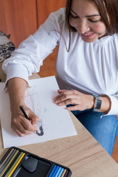 istock Designer makes new designs while painting them on paper with her colors 1365957923