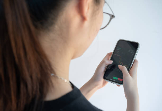 istock Woman checking Bitcoin price chart on digital exchange on her smartphone. 1365961720