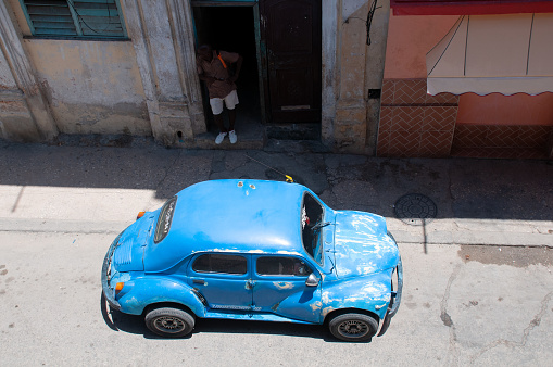 Small vintage car parked in front of a building on a street in old Havana. Havana. Cuba. May 12, 2015.