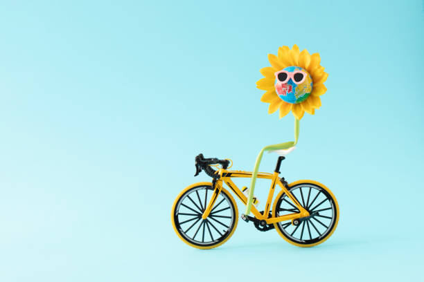 istock Globe or planet earth with sunglasses in sunflower rides a yellow  bicycle. Creative composition of nature blossom. Minimal nature  awareness concept 1365961903