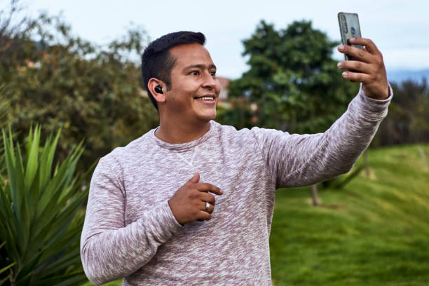 istock a man using his cell phone and wireless headphones to communicate 1365964681