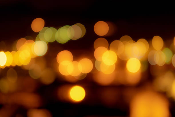 istock Blurred orange bokeh background. Blur abstract background of urban light. Warm light with beautiful pattern of round bokeh. Orange light in the night. Street lamp blurred lights in the city at night. 1365964776