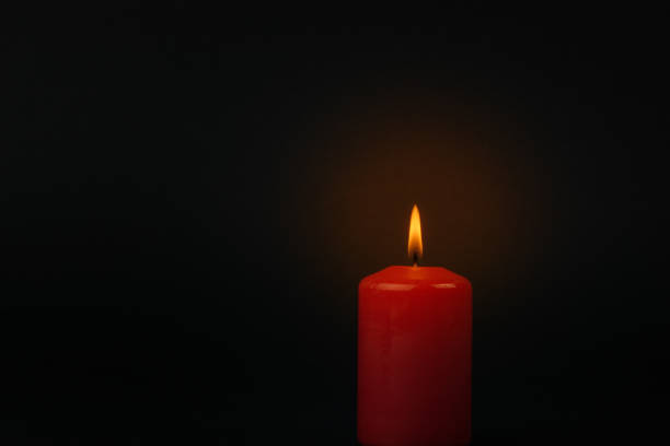 istock Lit a beautiful red candle on a black background. 1365965453