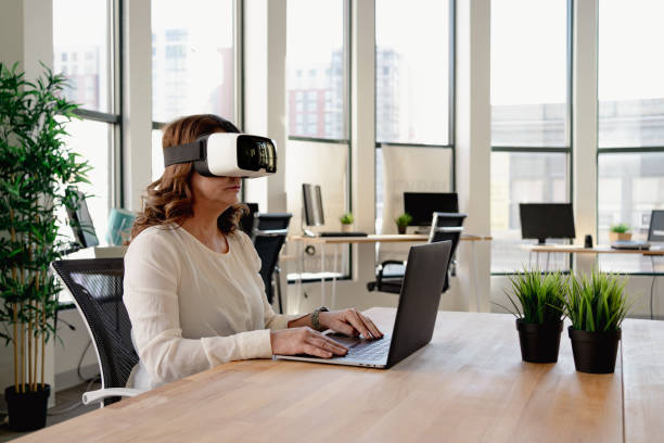 istock Senior woman in the office using VR glasses 1365966240