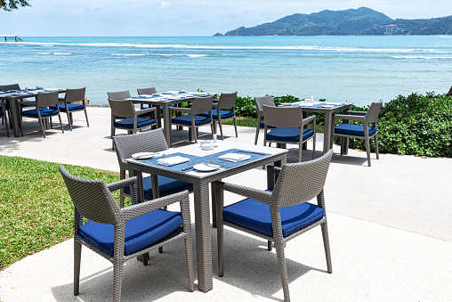 Tropical beach restaurant table and chairs at seaside