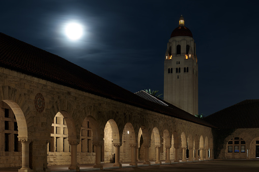 Palo Alto, California - January 19, 2021: Full moon rising over Hoover Tower via Main Quad at Stanford University