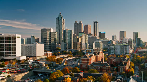 Drone Shot of Downtown Atlanta, Georgia at Sunset Aerial shot of Atlanta, Georgia on a sunny afternoon in Fall, hovering over Georgia Tech and looking along I-85 and I-75 towards Downtown office towers. atlanta skyline stock pictures, royalty-free photos & images