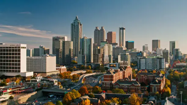 Aerial shot of Atlanta, Georgia on a sunny afternoon in Fall, hovering over Georgia Tech and looking along I-85 and I-75 towards Downtown office towers.