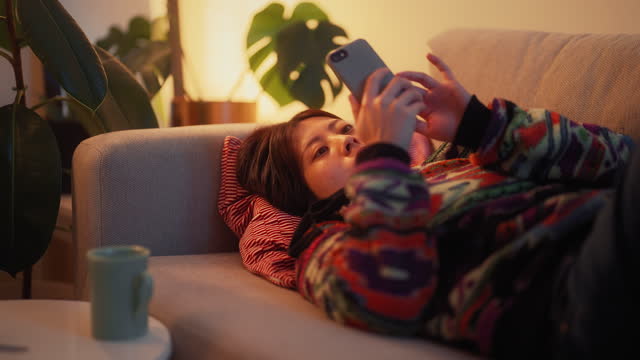 Young woman relaxing on sofa at night