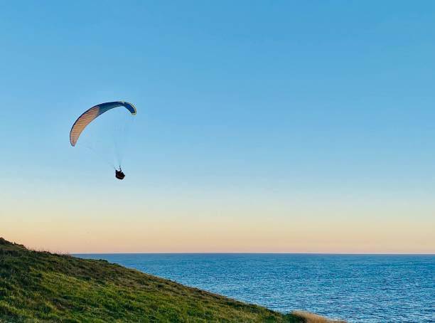 istock Paragliding off Headland at Sunset 1365977180