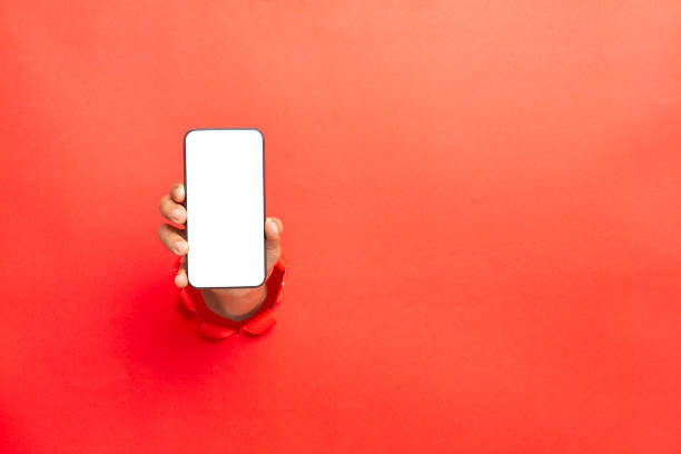 man hand holding a blank screen smart phone on Red background with clipping path stock photo