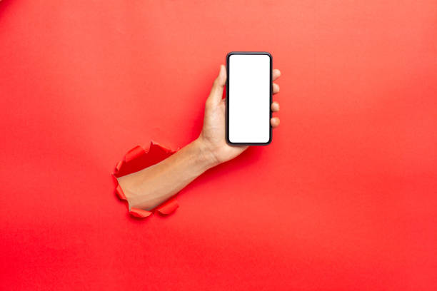 istock man hand holding a blank screen smart phone on Red background with clipping path 1365978181