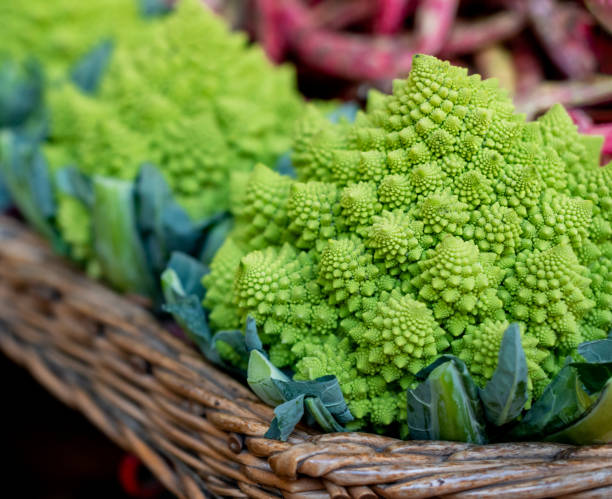 крупным планом на спелой капусте романеско на рынке - romanesco broccoli стоковые фото и изображения